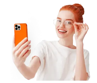 Девушка с улыбкой смотрит в телефон, выражая радость и удовлетворение.